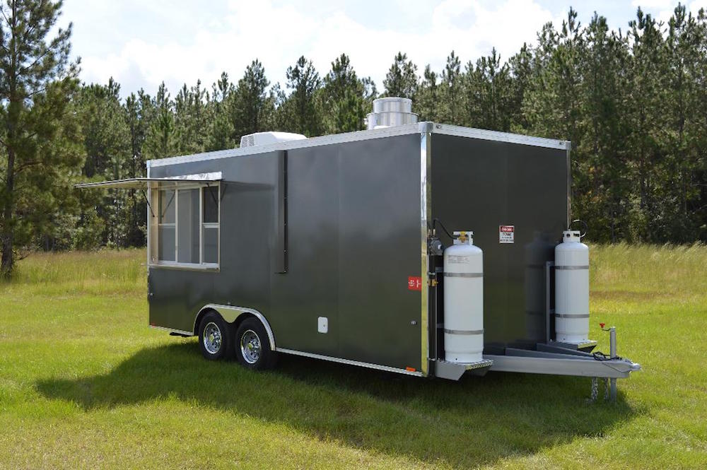 A gray trailer with two propane tanks on the side.