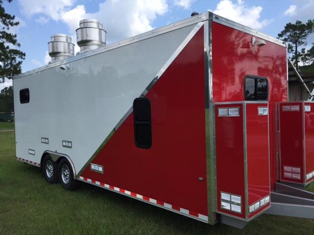 A red and white trailer with two vents on the side.