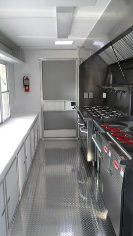 A kitchen with many stainless steel appliances and counters.