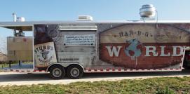 A large food truck parked on the side of a road.