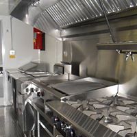 A kitchen with many stainless steel appliances and counters.