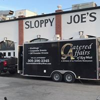 A black trailer parked in front of a building.