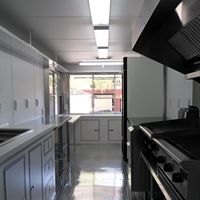 A kitchen with white cabinets and black appliances.