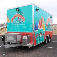 A food truck parked in the middle of a parking lot.