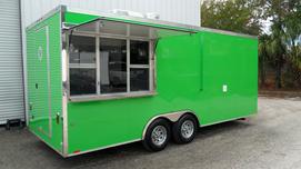 A green food truck parked in the street.