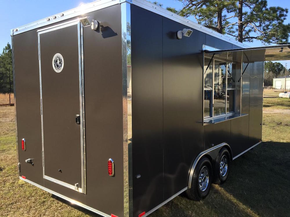 A black trailer with a door open and the back of it.